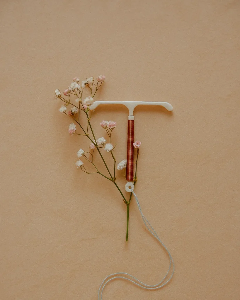 O que é DIU e como funciona? 4 Representação da relação entre o DIU e a fertilidade, simbolizada por um ramo de flores ao lado do dispositivo.