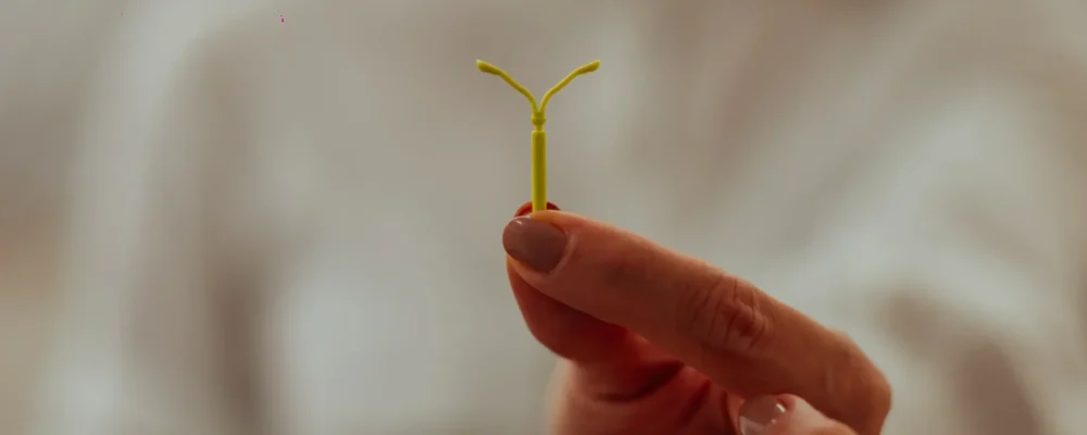 O que é DIU: Dra. Laís Carvalho ginecologista segurando um DIU, dispositivo usado como método contraceptivo intrauterino