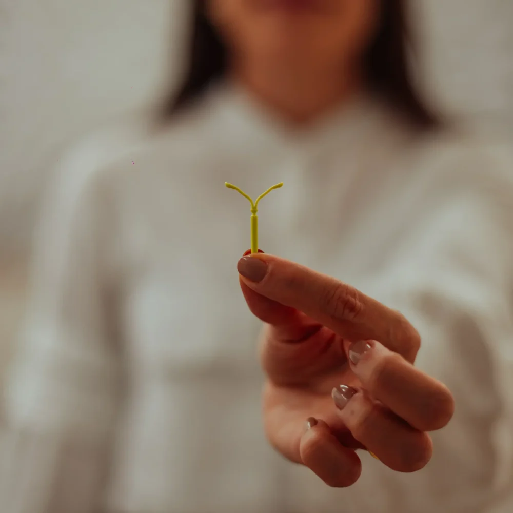 O que é DIU: Dra. Laís Carvalho ginecologista segurando um DIU, dispositivo usado como método contraceptivo intrauterino